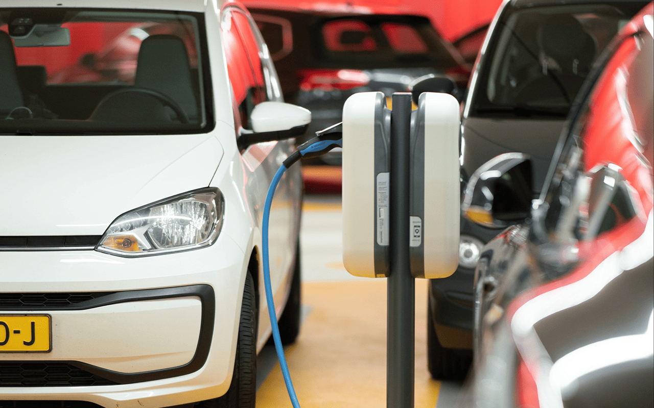 Hybrid EV car plugged in to charging station.png